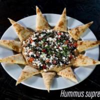 Humus Supreme · Our signature humus topped with roasted red peppers, capers, feta and black olives with a dr...