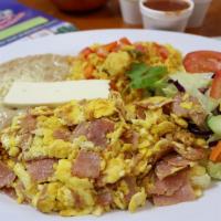 Huevos Con Jamon · Eggs and ham, three eggs scrambled with chopped ham, served with rice and refried beans topp...