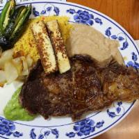 Ribeye Steak · Chuleta de res. Grilled tender and juicy ribeye steak, served with rice, refried beans, sala...