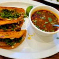 Birria tacos with birria soup · Three tacos filled with tender,juicy beef shank meat, topped with string cheese, onion, cila...