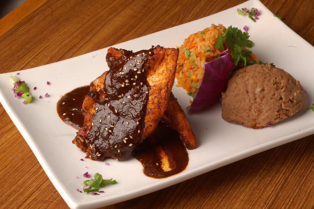 Pollo en Salsa · Grilled chicken breast simmered with choice of salsa. Served with Mexican rice and refried pinto beans.