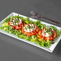 Caprese Salad · Thickly sliced tomatoes, fresh mozzarella cheese, and julienned basil topped with balsamic r...