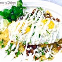 Chilaquiles con Huevos · Fried corn tortillas simmered in habanero hot salsa verde, topped with 2 fried eggs, your fa...