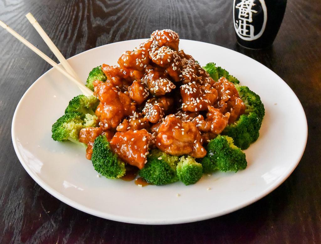 Sesame Chicken · Chunks of chicken marinated with garlic sauce, wine, brown, sweet  sauce surrounded by broccoli and showered with sesame seeds.