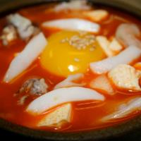21. Soon Dooboo · Soup dish with tofu, seafood or beef, vegetables, spicy soup and rice on the side.