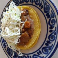 Chicharron Classic · Refried beans and pork cracklings cooked with homemade red sauce, and topped with cabbage, q...