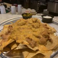 Nachos  · Warm tortilla chips slathered with beans and queso, served with jalapenos and sour cream. Ad...