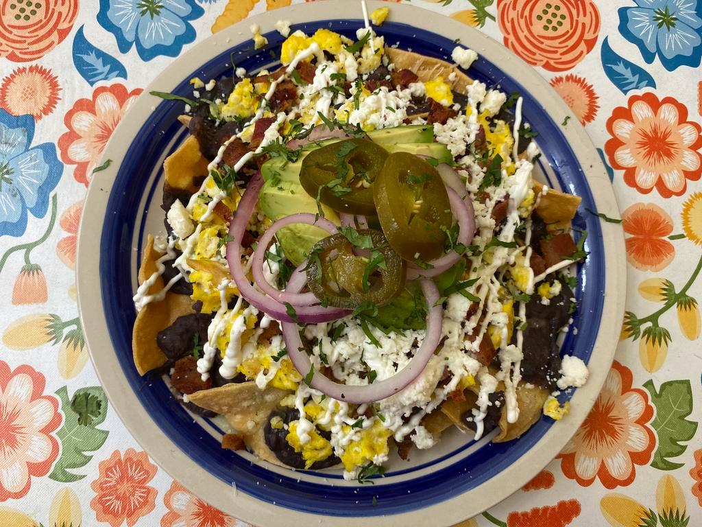 Breakfast Nachos · Scrambled eggs, bacon, sour cream, beans, avocado, Monterey cheese, queso fresco, pickled red onion, jalapenos, chips & chilaquiles salsa.