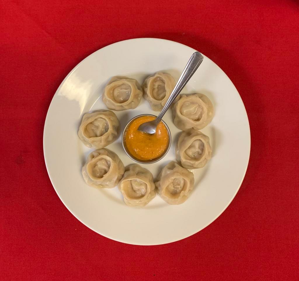 8 Piece Chicken Momo · Steamed dumplings filled with minced chicken, onion, cilantro, and spices. Served with himalayan sauce.