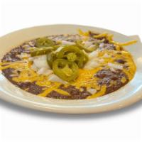 Texas Cafe Chili · Classic Texas red chili, garnished with cheddar cheese and diced onions. Served with cornbre...