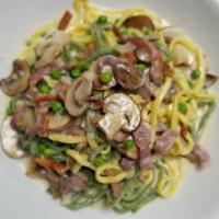 Paglia Fieno · Home-made green and white pasta, mushrooms, prosciutto di Parma, Green peas, cream sauce