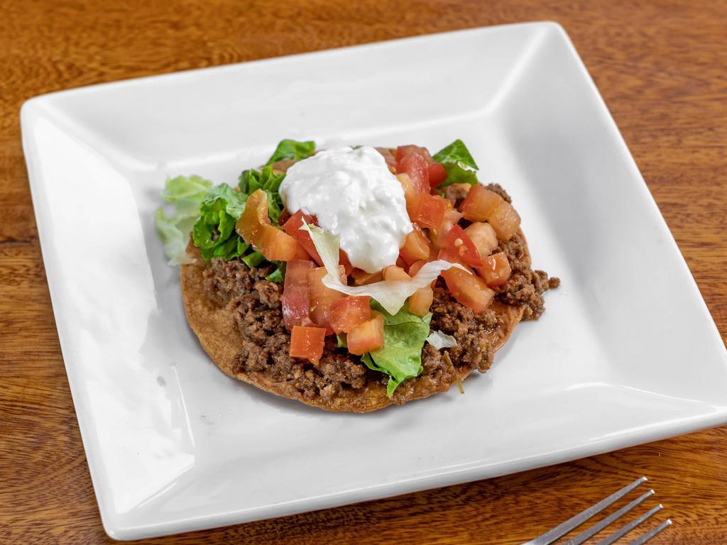 Tostada o chalupa · Crispy corn tortilla with your choice of meat, lettuce, tomatoes, sour cream, and beans.