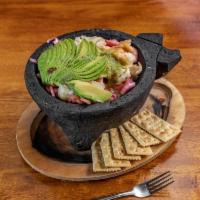 Aguachiles · Shrimp marinated and cooked in a spicy sauce, served with onions, cucumbers, and sliced avoc...