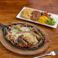 Alambre · Beef and chicken fajita, with bacon, ham, grilled onions and bell peppers, topped with Monte...