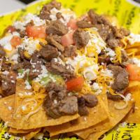 Nachos · Topped with beans, guacamole, sour cream, pico de gallo, cheese, and your choice of meat