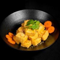 House Tofu · Fried tofu tossed in our tangy house tofu sauce. Topped with garlic, jalapenos, pickled carr...