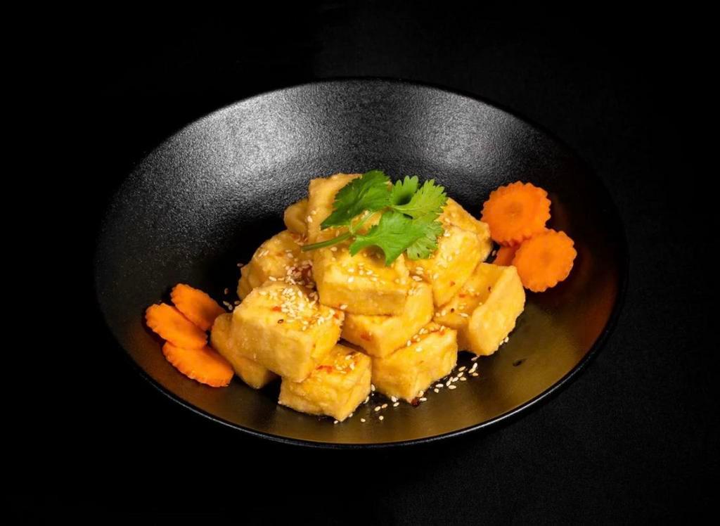 House Tofu · Fried tofu tossed in our tangy house tofu sauce. Topped with garlic, jalapenos, pickled carrots and daikon, onions, cilantro, and sesame seeds. Vegan.
