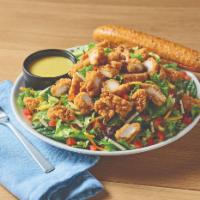 Crispy Chicken Tender Salad · Crispy chicken tenders on a bed of fresh greens topped with a blend of Cheddar cheeses, grap...