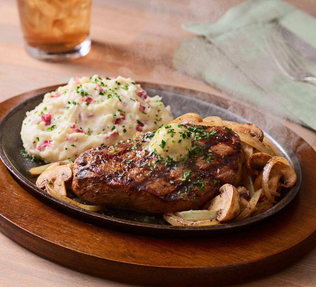 Bourbon Street Steak* · Big flavor from New Orleans. A grilled 8 oz. USDA Select top sirloin steak jazzed up with Cajun spices and garlic butter served sizzling on a cast iron platter with sautéed mushrooms and onions. Served with garlic mashed potatoes.