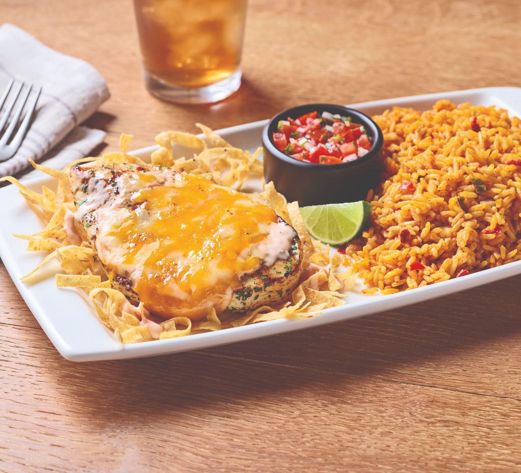 Fiesta Lime Chicken · A celebration of flavor, this dish delivers on every level. Grilled chicken glazed with zesty lime sauce and drizzled with tangy Mexi-ranch is smothered with a rich blend of Cheddar cheeses on a bed of crispy tortilla strips. Served with Spanish rice and house-made pico de gallo.