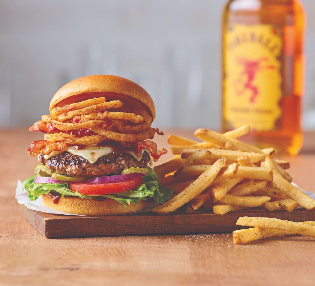 Whisky Bacon Burger · Savor the rich flavor in this tasty original. An all-beef patty topped with two slices of Pepper Jack cheese, crispy onions, two strips of Applewood-smoked bacon and Fireball® Whisky-infused steak sauce. Served on a brioche bun with lettuce, tomato, onion, and pickles.