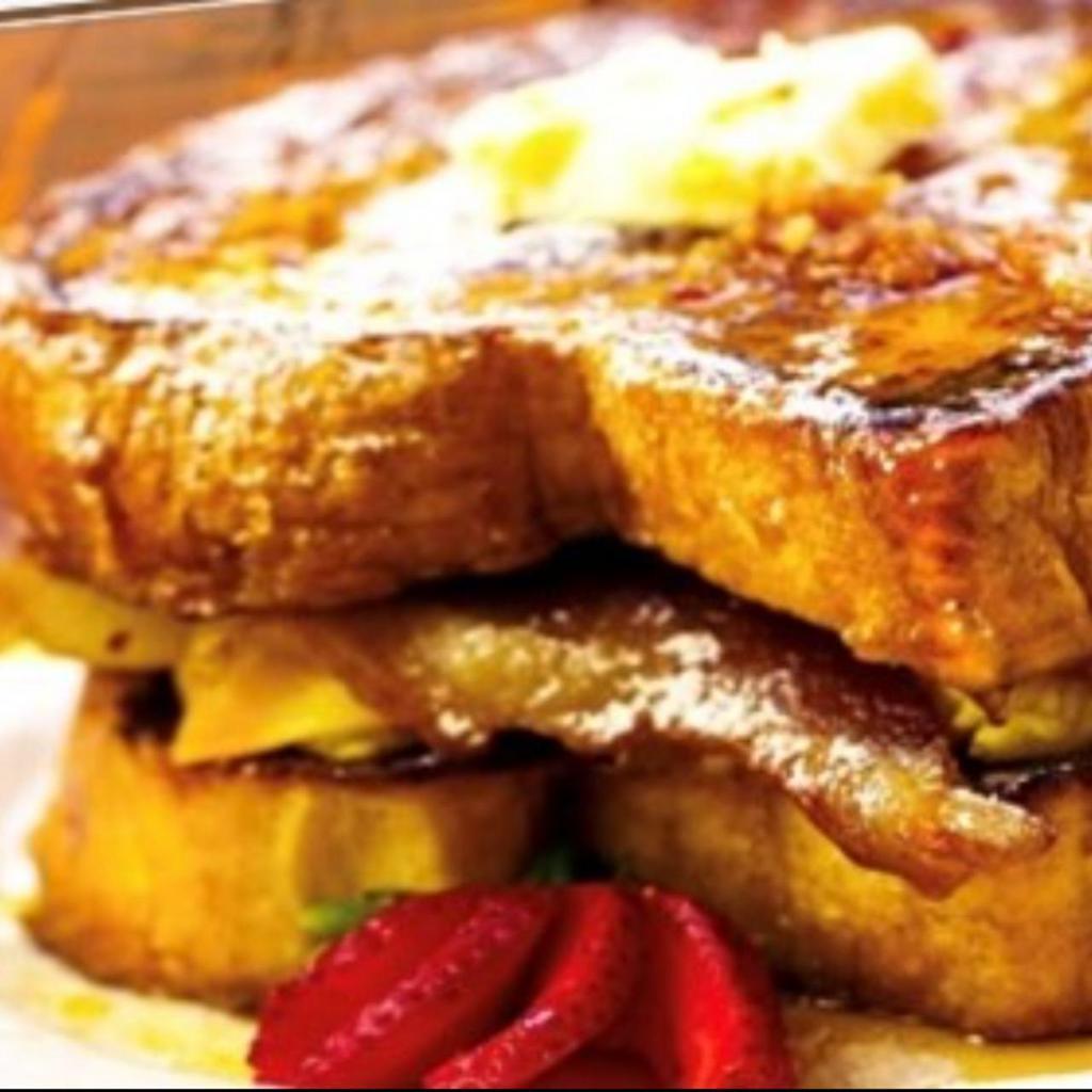 French Toast Sandwich · Crème Brulee Custard dipped Cinnamon Swirl Brioche Texas Toast, fried Eggs, Bacon, American Cheese, Bacon Maple Syrup, Powdered Sugar and Cinnamon Butter.