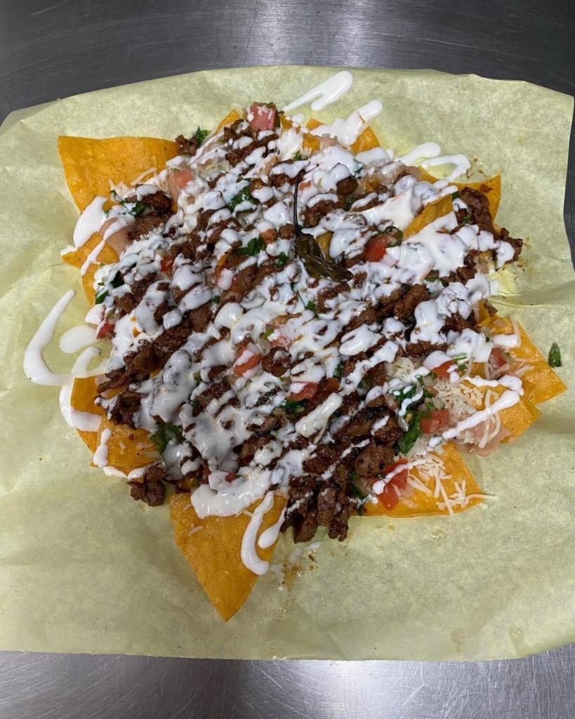 Super Nachos · Choice of:  carnitas, chicken, ground beef or pastor, loaded with beans, cheese, guacamole, pico de gallo, and sour cream.