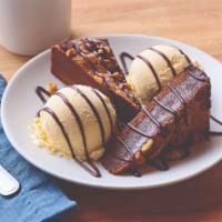 Blue Ribbon Brownie · Warm dark chocolate brownie with nuts. Served with vanilla ice cream & drizzled with hot fud...