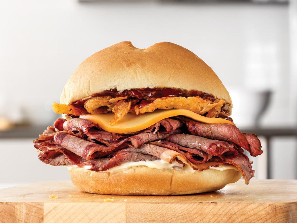 Smokehouse Brisket Sandwich · We set out to make a sandwich with layers of smoky flavor, and this is the result. Our brisket is smoked for at least 13 hours in a pit smoker in Texas. We top that delicious smoked beef with smoked gouda, crispy onions, mayo and BBQ sauce and serve it all on an artisan-style roll.