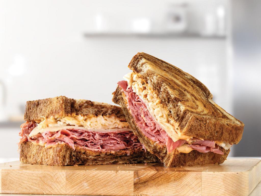 Corned Beef Reuben · Marbled rye bread filled with freshly sliced corned beef, melty Swiss Cheese, tangy sauerkraut and creamy Thousand Island dressing. This is a reuben sandwich inspired by the New York standard.