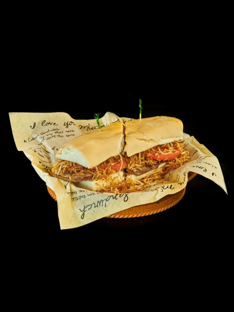 Pan con Bistec Sandwich · Thin sliced grilled steak, grilled onions, tomatoes, and string potatoes on Cuban bread. 