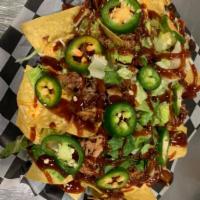 BBQ Nachos · Nachos the American way. Pulled pork with shredded lettuce, queso, jalapenos and BBQ sauce.