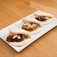 Pork Buns · Slice of savory pork belly dressed with Bonchon soy garlic sauce, topped with cucumbers, col...