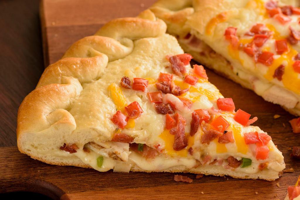 Chicken Bacon Stuffed Pizza (Baking Required) · Two layers of our Original Crust Stuffed with Grilled Chicken, Crispy Bacon, Roma Tomatoes, Mixed Onions, Whole-Milk Mozzarella, Creamy Garlic Sauce, topped with Crispy Bacon, Roma Tomatoes, Whole-Milk Mozzarella, Mild Cheddar, and Creamy Garlic Sauce