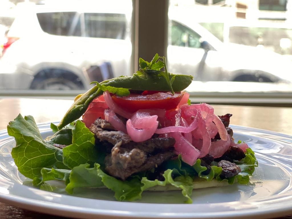 MAYAN STEAK TACO · Refried black beans, lettuce, tomato, pickled red onion and avocado.