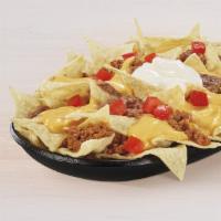 Nachos BellGrande® · A portion of crispy tortilla chips topped with warm nacho cheese sauce, refried beans, seaso...