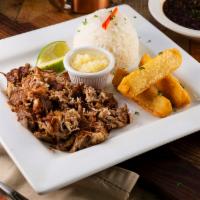 Lechon Asado · Cuban style slow roasted pork served with rice, fried yuca and your choice of beans. So juic...