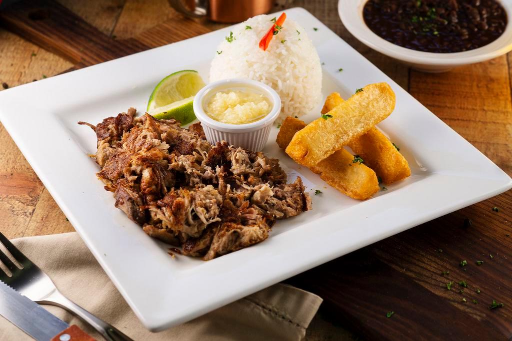 Lechon Asado · Cuban style slow roasted pork served with rice, fried yuca and your choice of beans. So juicy and full of popping flavors!