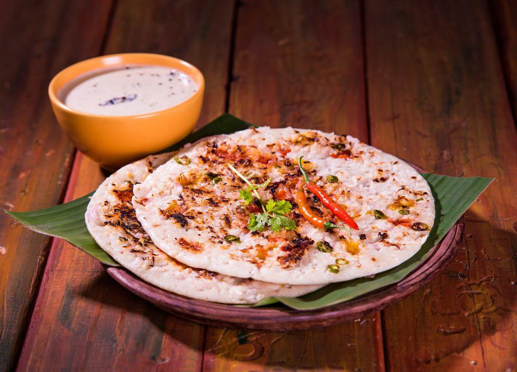 Uttappam · Pancakes made of fermented batter of rice and lentil and topped with mixed vegetables and onions. Served with chutney and sambar.