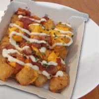Loaded Tater Tots · Crispy, golden tater tots loaded with all the goods. Cheddar cheese, ranch, bacon, and chive...