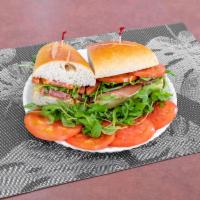 A10. Prosciutto Avocado, Arugula and Tomato Sub Lunch · A long sandwich on a roll.