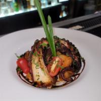 Grilled Herb Octopus · With black olives, grape tomatoes, chickpeas red pickles and onions.