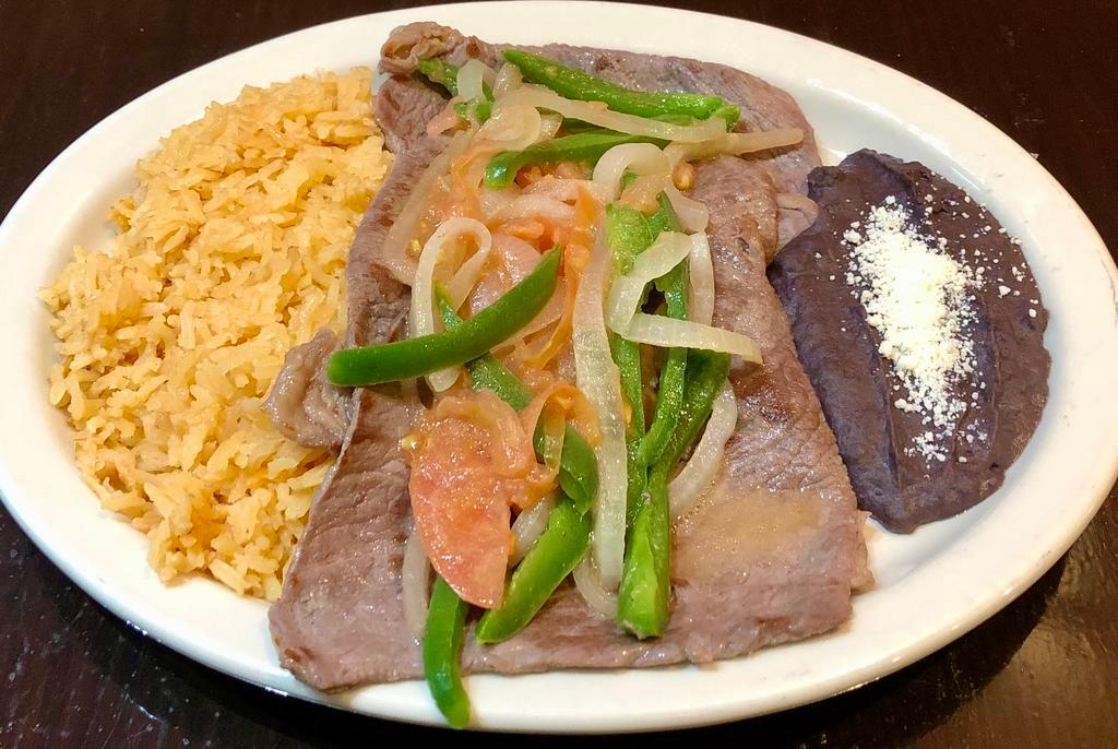 Bistec Encebollado · Grilled steak with onions. Served with rice and beans.