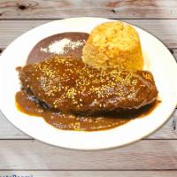 Mole Poblano de Pollo · Chicken with brown mole sauce served with rice, beans and tortillas.