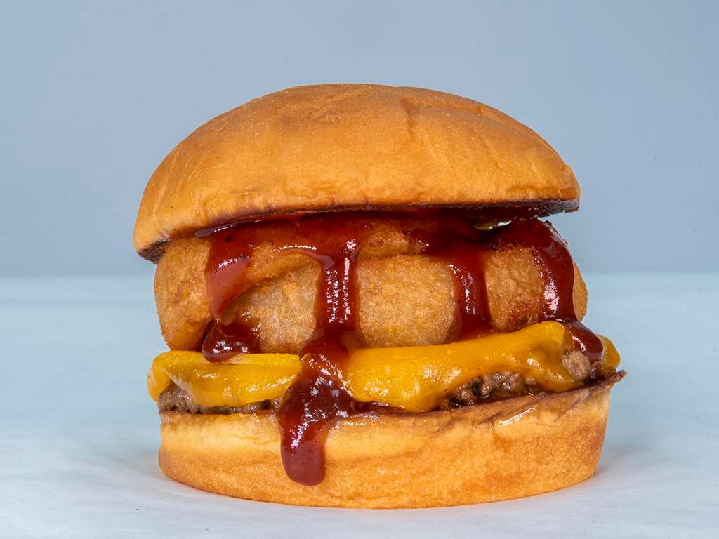The Onion Ringer · impossible patty, cheddar cheese, smoked bacon, onion rings, bbq sauce served on King's Hawaiian roll.