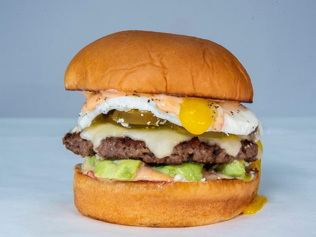 Chipotle Avocado Burger · impossible patty, white American cheese, avocado, pickled jalapenos, Cotija cheese, fried egg, and chipotle aioli. Hormone and antibiotic free beef served on King's Hawaiian roll.