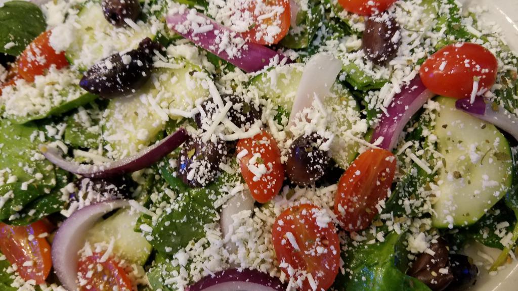 Greek Salad · Cucumbers, tomatoes, red onions, Kalamata olives and feta cheese on a bed of spinach leaves with oregano and feta vinaigrette.