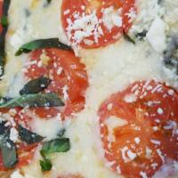 Margherita Pizza · Fresh basil, Roma tomatoes, and feta cheese atop an olive oil and garlic base.