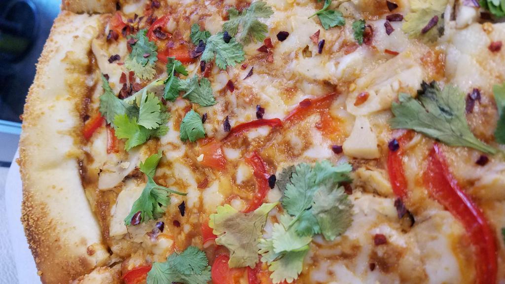 Spicy Thai Pizza · Garlic chicken, roasted red peppers, crushed red peppers & cilantro on top of a spicy peanut sauce base.