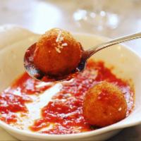 Arancini di Riso · Homemade safron risotto balls stuffed with angus Beef and pea ragù served over a San Marzano...